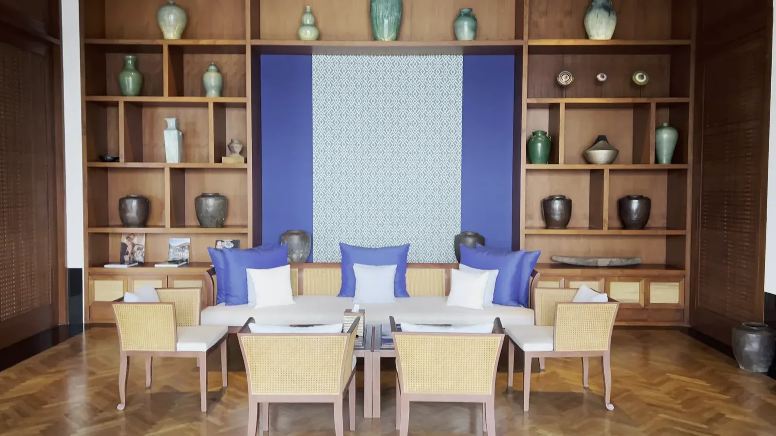 The lobby lounge at The Sira Lombok, with teak shelving and blue and white seating